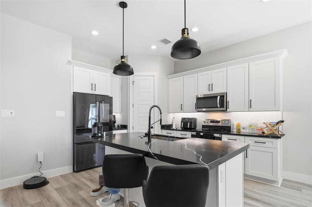 7733 Indian Ridge Trail Dallas, TX 75232 - Photo 5 of 30 a kitchen with stainless steel appliances granite countertop a sink a stove a microwave and cabinets