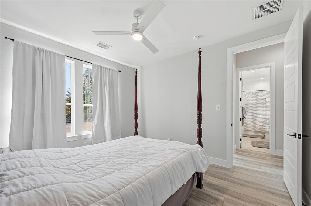 7733 Indian Ridge Trail Dallas, TX 75232 - Photo 8 of 30 a bedroom with a large bed and a chandelier