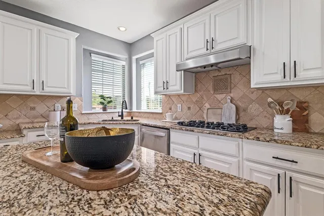 a kitchen with a stove a sink and cabinets