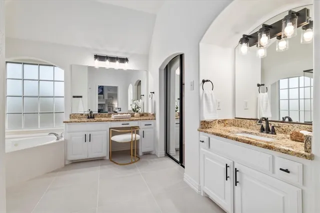 a bathroom with a granite countertop sink mirror and bathtub