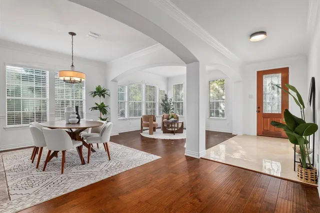 a dining room with furniture wooden floor a chandelier and a rug
