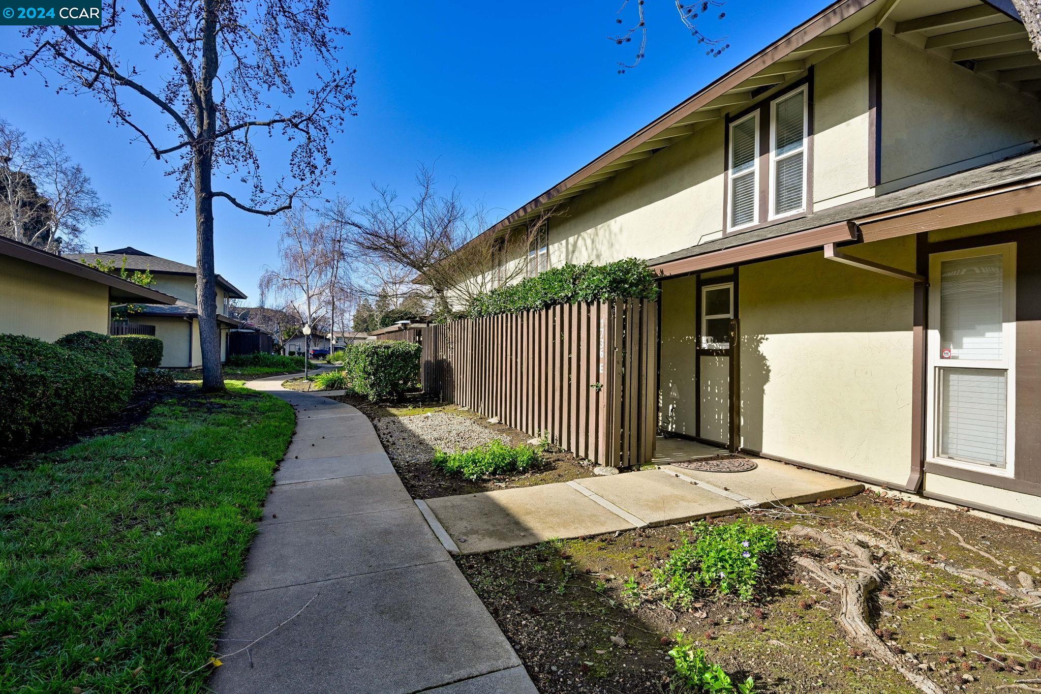 1736 Sapling Court, Unit E Concord, CA 94519 - Photo 1 of 1 a front view of a house with garden