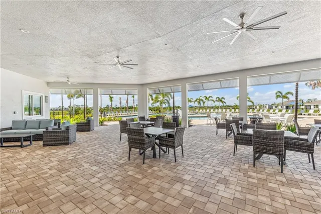a room with lots of tables a large window and chairs