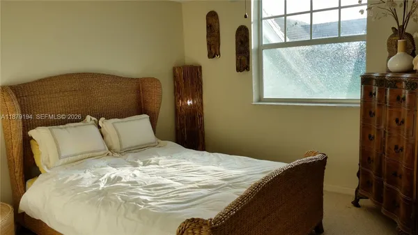 a bed sitting in a bedroom next to a window