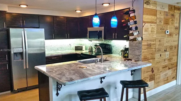 a kitchen with stainless steel appliances granite countertop a sink a refrigerator and a stove
