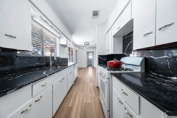 a kitchen with stainless steel appliances a sink dishwasher stove microwave and cabinets
