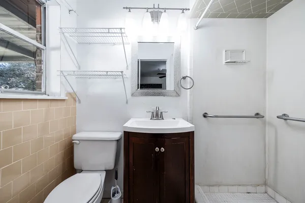 a bathroom with a toilet a sink and mirror