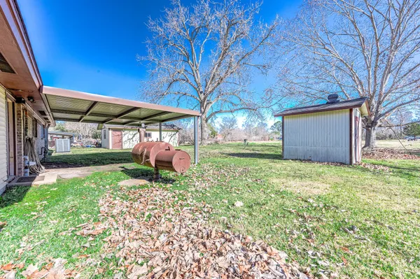 a view of a backyard with table and chairs and a barbeque