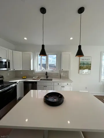 a kitchen with a sink a stove and chairs