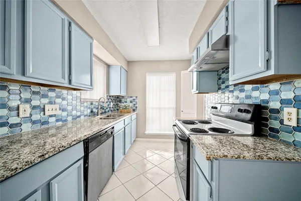 a kitchen with stainless steel appliances granite countertop a sink stove and cabinets