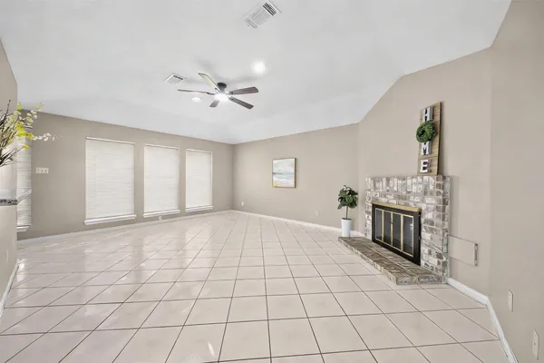 a view of an empty room with a fireplace and a window