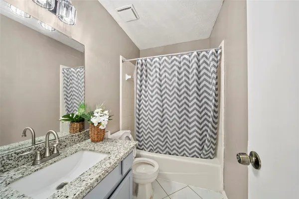 a bathroom with a granite countertop sink a toilet and mirror