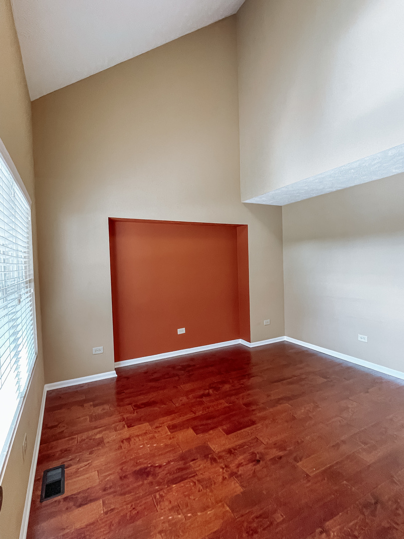 3205 Old Castle Road Joliet, IL 60431 - Photo 3 of 25 a view of an empty room with wooden floor and a window