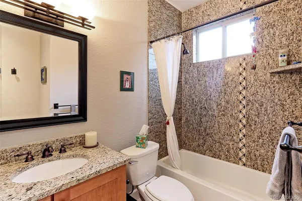 a bathroom with a granite countertop sink toilet and shower