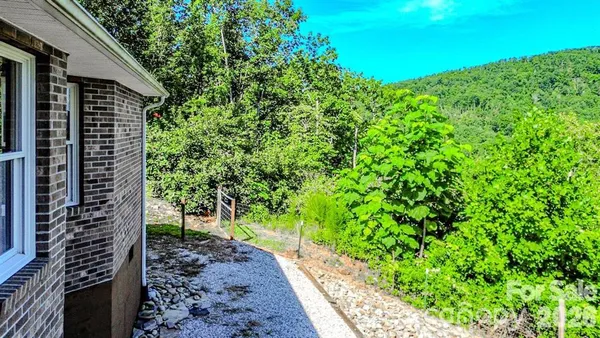 an aerial view of a house with a yard and large trees