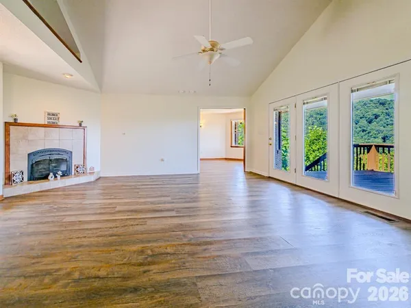 a view of an empty room with window and wooden floor
