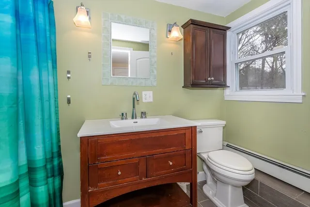 a bathroom with a toilet a sink and mirror
