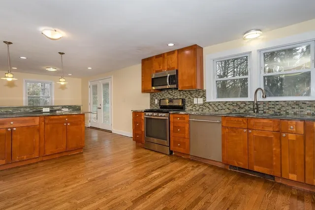 a large kitchen with stainless steel appliances granite countertop a stove a sink and a microwave