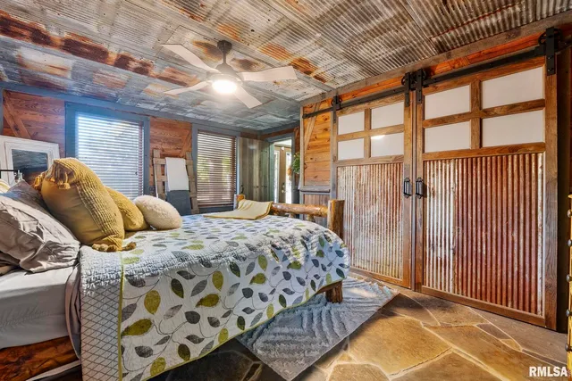 a bedroom with a bed next to a window