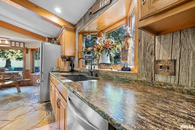 a kitchen with stainless steel appliances granite countertop a sink and a counter space