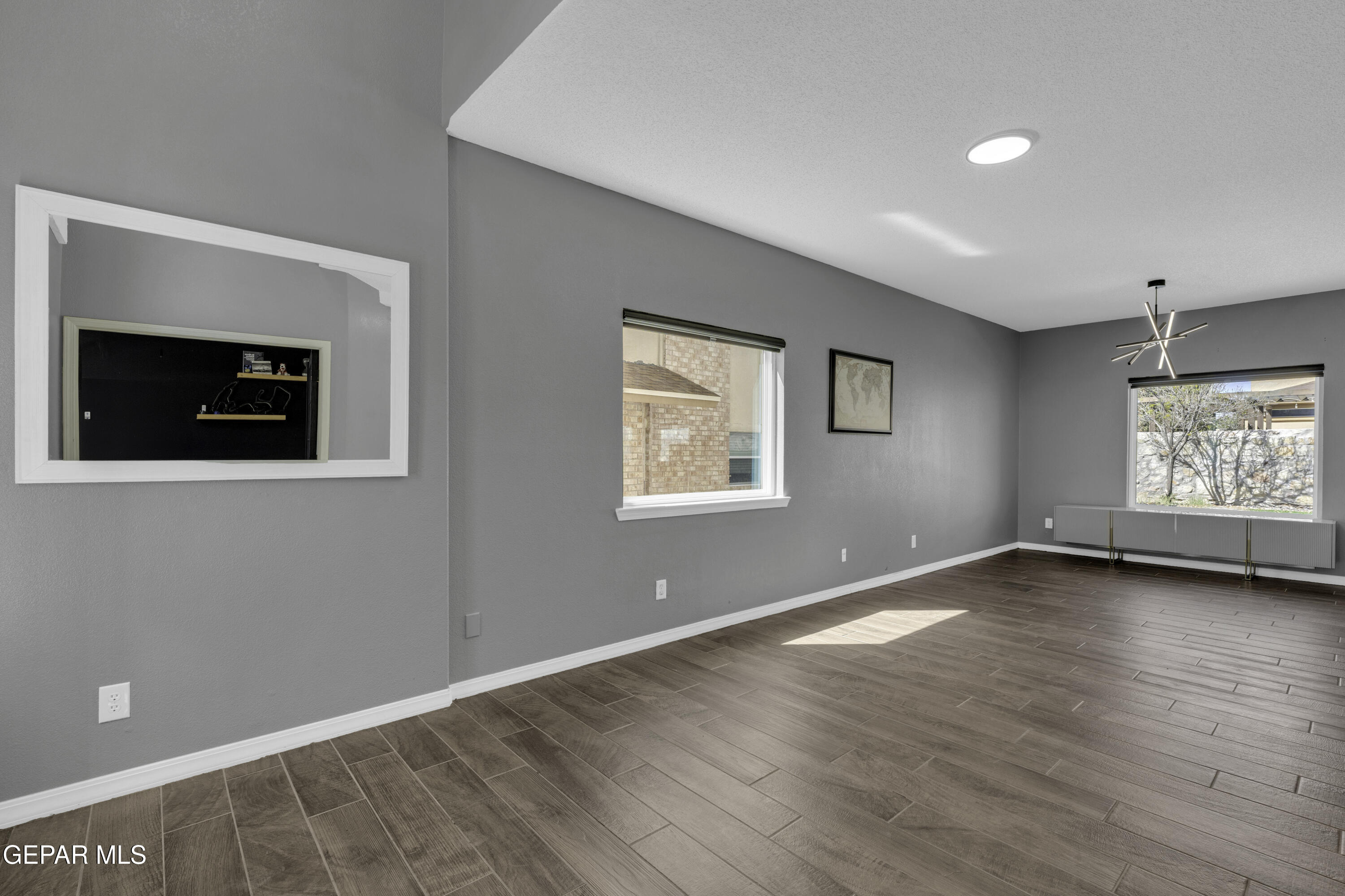 6341 Cougar Ridge Lane El Paso, TX 79912 - Photo 18 of 71 a view of an empty room with a window and wooden floor