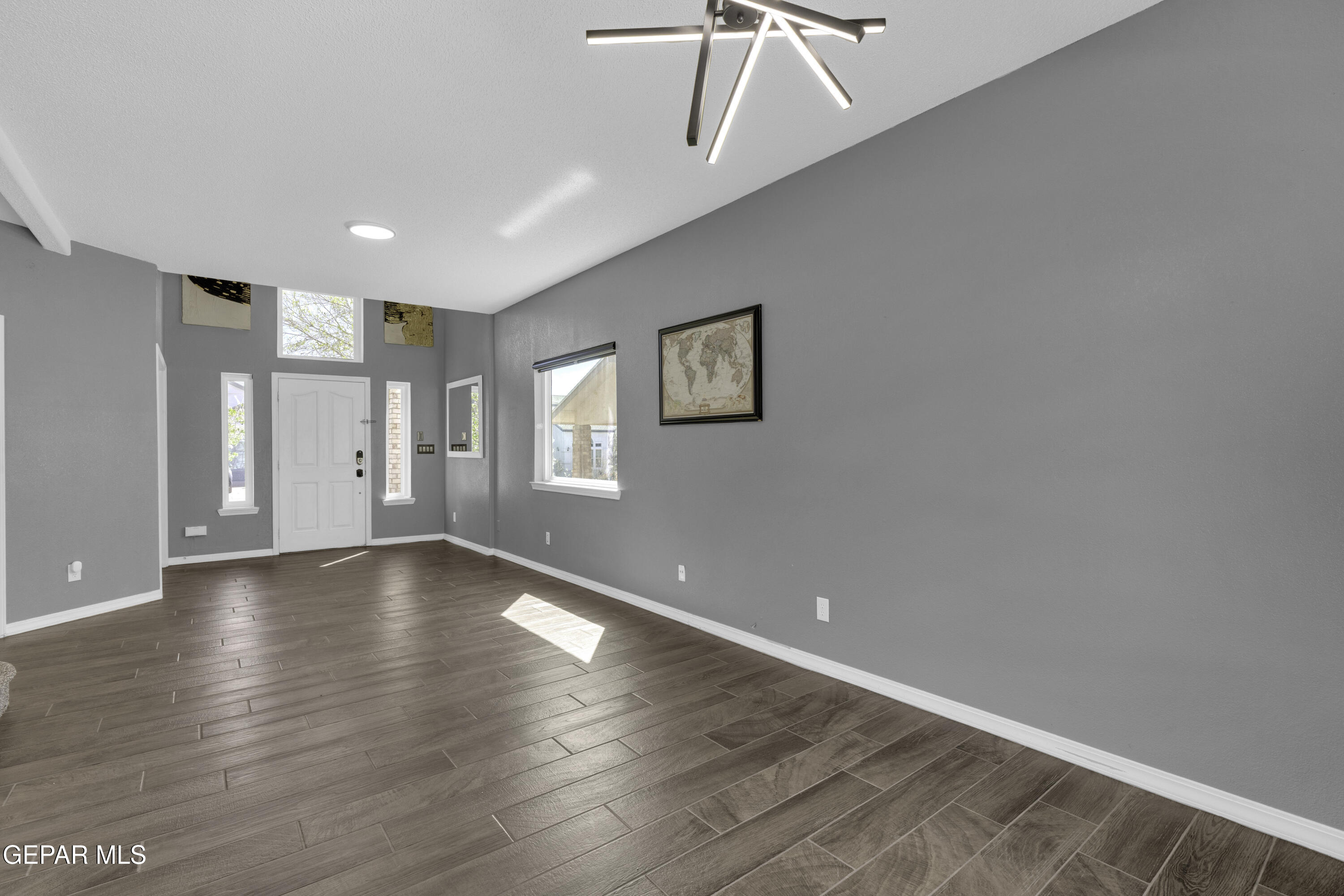 6341 Cougar Ridge Lane El Paso, TX 79912 - Photo 19 of 71 a view of an empty room with a window and wooden floor