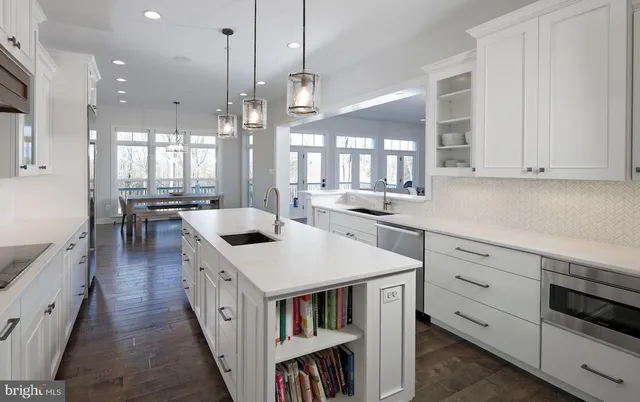 a kitchen that has a lot of white cabinets and wooden floor