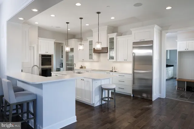 a kitchen with stainless steel appliances kitchen island a refrigerator sink and cabinets
