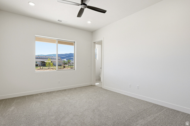4978 North 75 East Enoch, UT 84721 - Photo 18 of 60 Spare room featuring light carpet, a mountain view, a ceiling fan, and recessed lighting