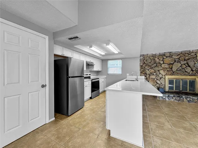 a kitchen with stainless steel appliances kitchen island a refrigerator sink and cabinets