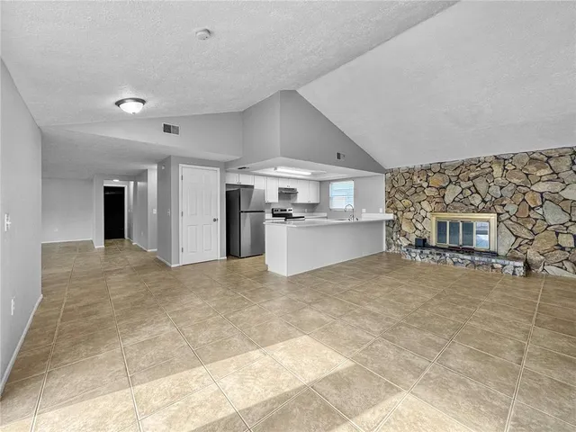 a view of a kitchen with a sink and a refrigerator in it