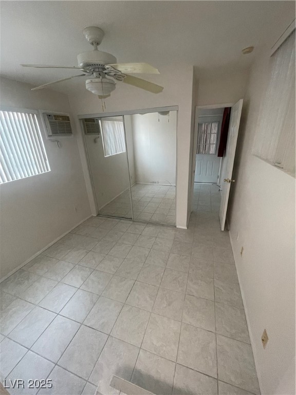 4641 Royal Ridge Boulevard Las Vegas, NV 89103 - Photo 10 of 38 Unfurnished bedroom featuring light tile patterned floors, a ceiling fan, an AC wall unit, and a closet