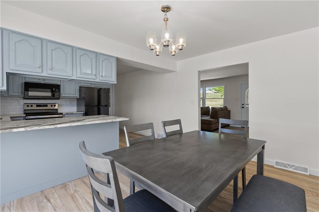 952 Achortown Road Beaver Falls, PA 15010 - Photo 7 of 43 a dining room with wooden floor a chandelier a wooden table and chairs