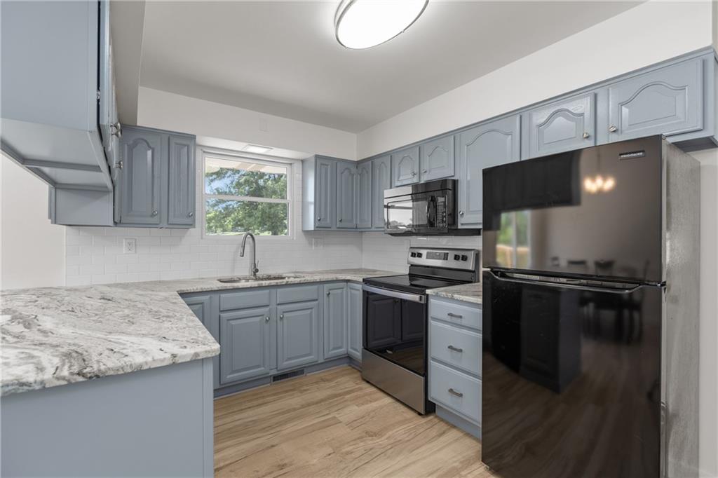 952 Achortown Road Beaver Falls, PA 15010 - Photo 8 of 43 a kitchen with granite countertop a sink stove and refrigerator