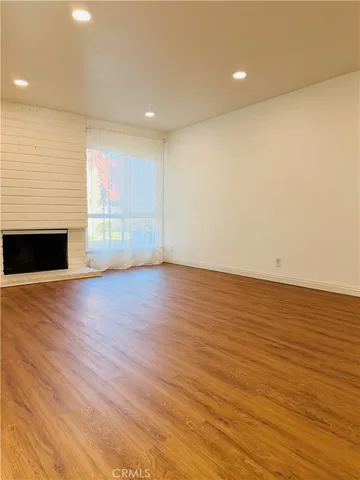 an empty room with wooden floor and fireplace