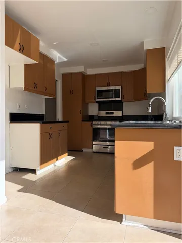 a kitchen with stainless steel appliances kitchen island granite countertop a refrigerator and a stove top oven