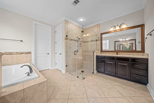 a spacious bathroom with a granite countertop sink mirror and a bathtub