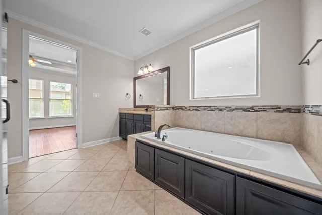 a spacious bathroom with a tub sink and mirror