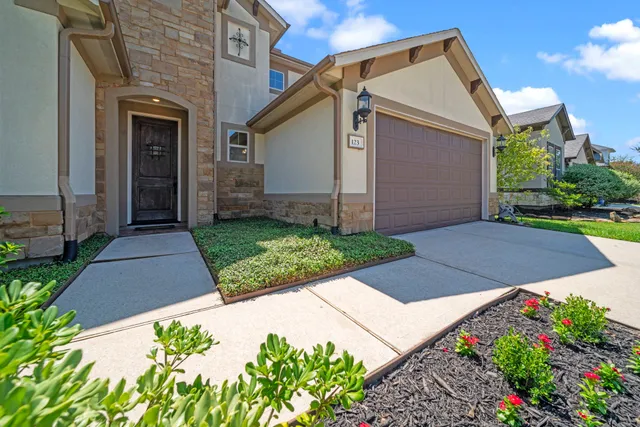 a front view of a house with a yard and flower plants