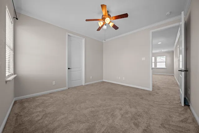 an empty room with closet and ceiling fan