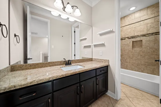 a bathroom with a granite countertop sink a light fixture and a mirror