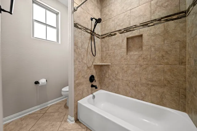 a bathroom with a white bath tub a shower and a sink