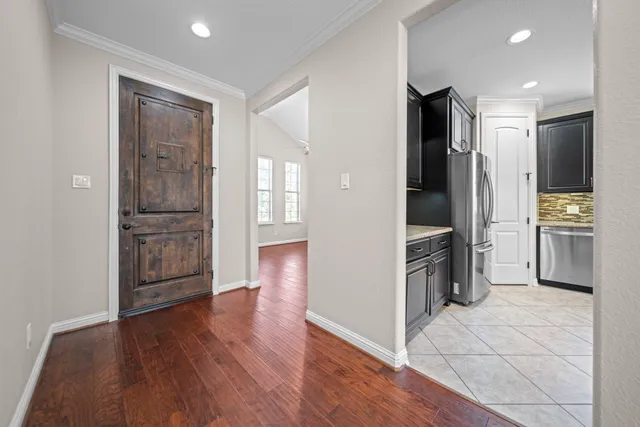 a view of a kitchen with refrigerator and wooden floor