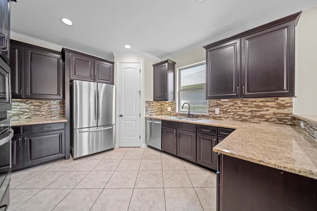a kitchen with stainless steel appliances granite countertop a refrigerator and a sink