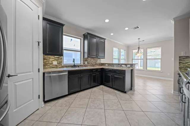 a kitchen with stainless steel appliances granite countertop a stove a sink and a refrigerator