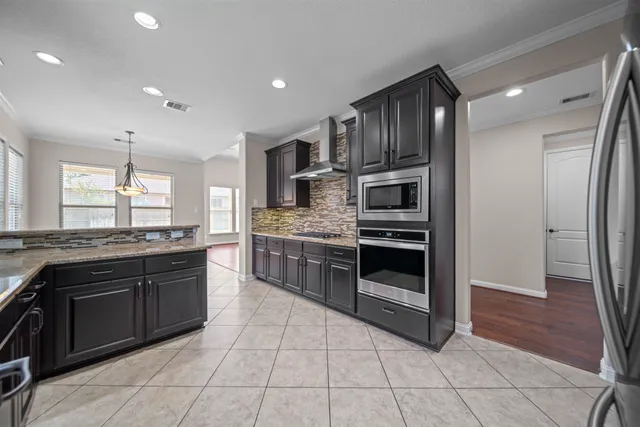 a kitchen with stainless steel appliances granite countertop a refrigerator and a sink