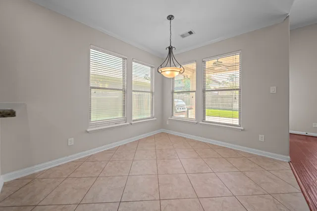 an empty room with windows and chandelier