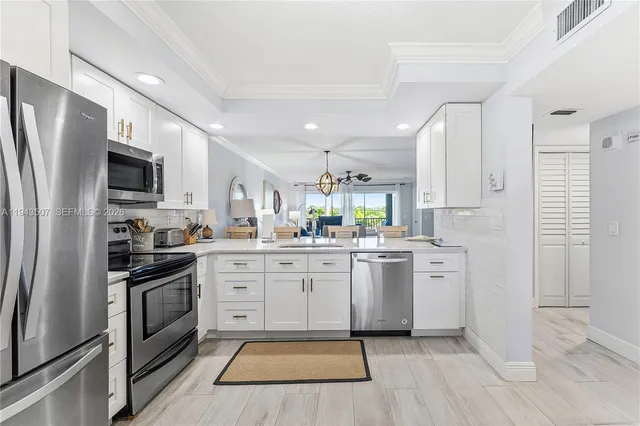 a kitchen with white cabinets stainless steel appliances and sink