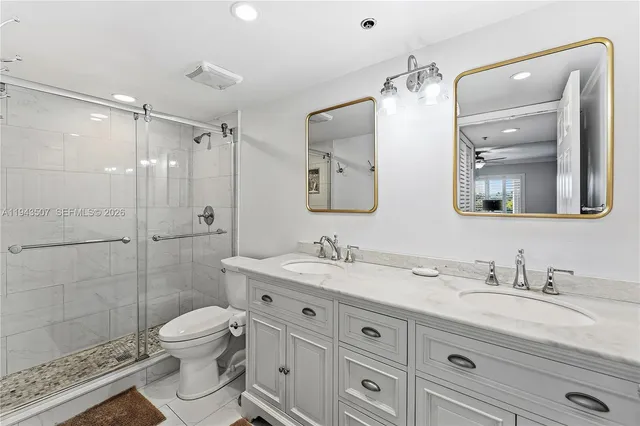 a bathroom with a granite countertop sink mirror and toilet