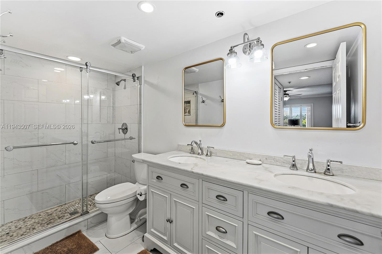 275 Palm Avenue, Unit B207 Jupiter, FL 33477 - Photo 12 of 29 a bathroom with a granite countertop sink mirror and toilet